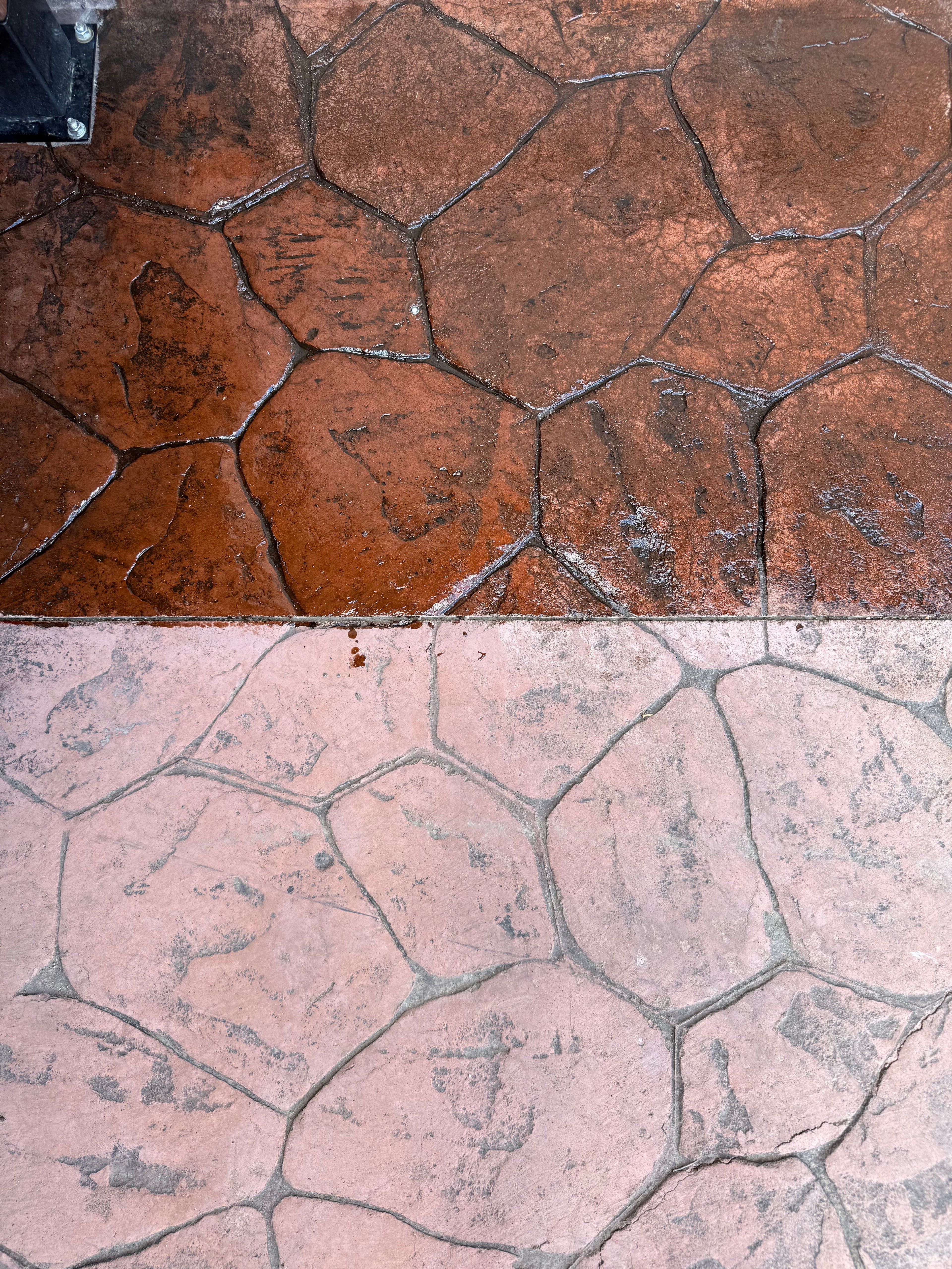 Close-up of stone pavement with a transition from brown to pink stones.